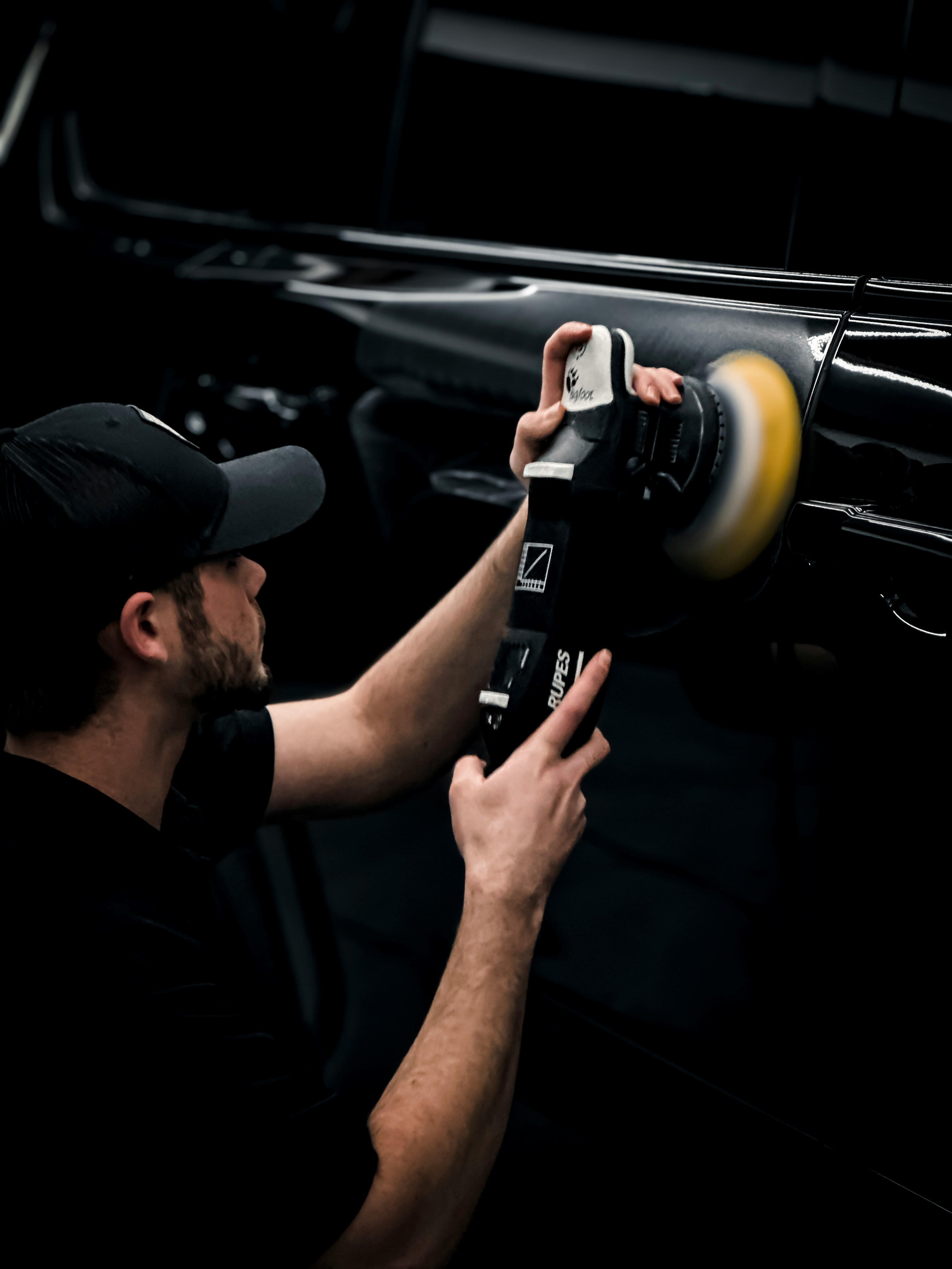 Auto detailer polishing a car